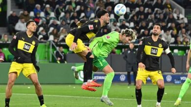 Dortmund holds on with 10 men for 1st away win in Bundesliga